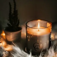 This is my classic C&C branded jar candle, creating a warm and inviting glow. Placed on a soft surface with fairy lights, it shows how a simple scented candle can transform your space into a cozy sanctuary.
