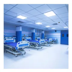 The post-operative recovery ward at Memorial Hospital and Research Centre in Kerala. The space is designed for cleanliness and function, with ample room between beds and a sterile, calming blue and white color scheme.
