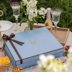 A close-up of our elegant blue gift box, tied with a brown ribbon. It’s designed to hold a dozen of our handcrafted dessert cups, making it a substantial and impressive gift for any celebration.