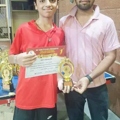 A student poses with his trophy and certificate alongside one of our coaches. This highlights the strong player-coach partnership we build to guide players through their competitive journey.