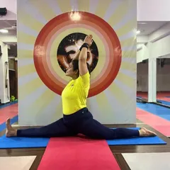 A student demonstrates a deep Hanumanasana (Full Split), showcasing advanced flexibility in the hamstrings and hips.