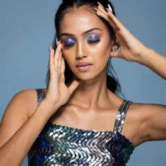 An emotive beauty shot, with the model's eyes closed, focusing on the purple eyeshadow.