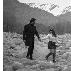 A timeless black and white shot from a post-wedding session in Manali, capturing a quiet walk across a rocky riverbed.