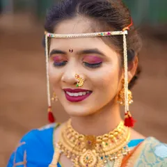 A close-up shot to appreciate the artistry of the bridal look. This photo highlights the detailed makeup, the traditional bindi, and the intricate design of her gold necklace and mundavalya. It’s a celebration of bridal beauty.
