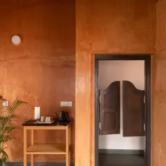 The warm, earthy tones of the Lohi plaster finish in the Vinaya residence in Bangalore. The color palette is not chosen from a catalog but remembered from the soil itself, giving the walls a natural, timeless texture.