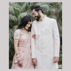 A sweet, candid moment between a couple dressed in stunning traditional attire. Her gentle smile as she holds his arm captures a feeling of comfort and affection.