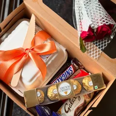 For the ultimate sweet tooth, this mini gift box is packed with treats. It features a bento cake, a small bouquet of roses, and a selection of popular chocolates like Ferrero Rocher, Galaxy, and Snickers.