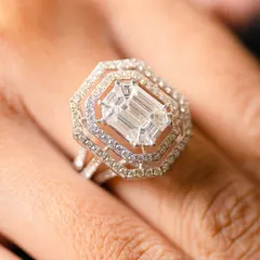 The elegance of pristine white, captured in every sparkle. This emerald-cut diamond, set in a magnificent triple halo, is a true statement of luxury and sophistication.