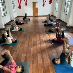 During the same Yin Yoga class, students are holding Ananda Balasana (Happy Baby Pose). This posture is excellent for releasing tension in the hips and lower back, which is a common issue from sitting for long hours.
