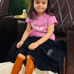 Pampering is for all ages. This little client is enjoying a fun and gentle leg treatment, making her salon visit a special treat.