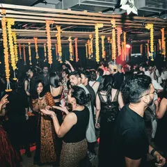 A packed dance floor during a festive 'Phoolon Ki Holi' themed Sangeet. The decor, the energy, and the music all came together for a truly memorable night of naach and masti.