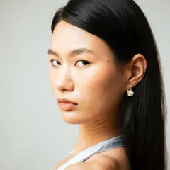 A clean beauty headshot with minimal makeup, focusing on the model's natural features and direct gaze.