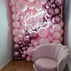 This full balloon wall is a fantastic photo opportunity for a birthday party. Created with shades of pink and metallic rose gold, it features an integrated neon sign and provides a luxurious, immersive backdrop for guests.