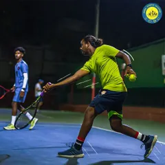 Unleash a powerful forehand on our pristine hard courts. This player is captured in a moment of pure focus and energy during a night session, showcasing our excellent court lighting.