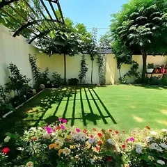 A perfect backyard retreat featuring a pristine lawn, a flower border with colorful roses, and a pergola casting beautiful shadows. This is the kind of idyllic outdoor living space we create.