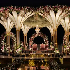 A breathtaking mandap designed for a fairytale wedding. The stage features grand floral arches, a golden reflective aisle, and a canopy of hanging baby's breath, creating a truly magical atmosphere.