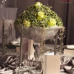 A beautiful floral centerpiece in a glass vase, surrounded by candles and fine glassware. These small details in our table decor contribute to a memorable and aesthetic atmosphere for your event.