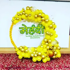 A beautiful 'Mehendi' backdrop for your pre-wedding ceremony. This circular balloon arch is made with yellow and gold balloons, with a custom 'Mehendi' sign in Hindi at the center.