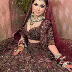 A close-up of our beautiful client in a maroon velvet bridal lehenga. The intricate embroidery and deep color make it a perfect choice for a winter wedding.