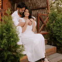 A moment of pure, uninhibited laughter on a rustic wooden porch. Dressed in coordinated white, this couple's joy is infectious, showcasing a perfectly candid moment from their pre-wedding shoot.