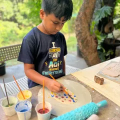 A young artist completely absorbed in painting his creation at my weekend pottery retreat. I provide all the materials and guidance for kids to let their imagination run wild.