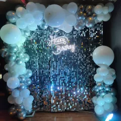 We can create shimmer backdrops in various colors. This setup uses a silver sequin wall but is framed with light blue and silver balloons for a cooler, icy-themed birthday party.