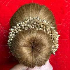 A top-down view of a perfectly formed donut bun. This fundamental technique is essential for many bridal and formal hairstyles, and we practice it until it's perfect.
