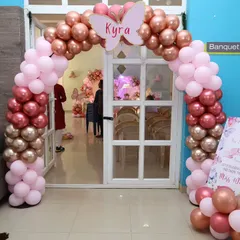 A lovely entrance for a butterfly-themed party, with a rose gold and pink balloon arch topped with a custom butterfly cutout.