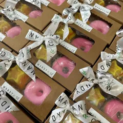 A batch of super cute donut and star-themed return favor boxes, all tied up with my branded ribbon. Each box contains a pink donut soap and a layered star soap.