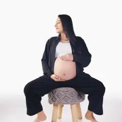 A relaxed and natural pose on a modern stool. This casual studio shot is all about capturing the peaceful and happy moments of waiting for your baby.