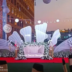 The anniversary party stage against the evening sky. The glowing structures and overhead lights create a magical atmosphere for the celebration.