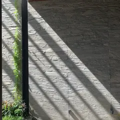 Light is a material I use to create art. Here, strong diagonal shadows are cast across a wall of rough-hewn stone, creating a dramatic, ever-changing pattern that connects the home to the rhythm of the day.