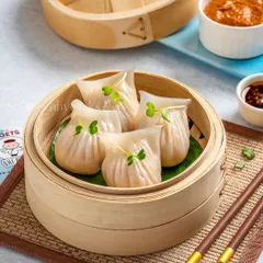 Translucent crystal shrimp dumplings served in a traditional bamboo steamer, highlighting their delicate texture and filling.