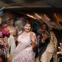 A candid shot of the bride enjoying the sangeet, surrounded by her dancing friends.