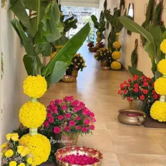We created a blooming pathway for this event using a vibrant mix of traditional flowers. The walkway is lined with arrangements of yellow marigolds and bright pink roses in brass pots for a colorful and celebratory feel.