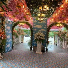 This is the view from inside the hall for the same grand naming ceremony. The ceiling is decorated with thousands of pink flowers and hanging lights, creating an enchanting, forest-like atmosphere.