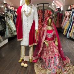 A timeless choice for the big day. This classic red bridal lehenga with intricate embroidery, paired with a regal white and gold sherwani, is a stunning combination for a traditional wedding ceremony.
