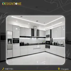 A showcase of a modern, ultra-luxury modular kitchen in a striking high-gloss white and black theme. This L-shaped layout features integrated appliances, handleless cabinets, and layered lighting with spotlights and strip lights, creating a space that is both functional and visually stunning.