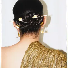 The details make the look. Here, the focus is on the intricate braided bun and custom hair accessories that completed this experimental outfit.