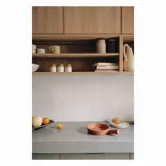 Shoji-screen-like glass panels open to reveal this olive green and wood-clad kitchen. The design allows the kitchen to be either an open part of the living space or a discreetly hidden room. The open shelving provides a space for curated pottery and essentials, blending utility with beauty.