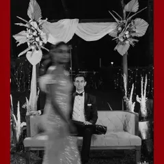 An artistic shot using motion blur, capturing the bride in movement while the groom sits in focus, creating a dynamic and modern portrait.