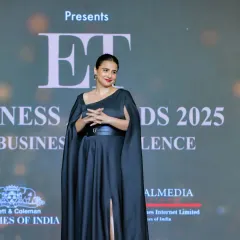 A wider shot of Vidya Balan on the ET Business Awards stage, showing the event branding in the background. This image connects the high-profile guest with the event itself, adding credibility and prestige.