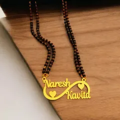 A modern take on a couple's necklace, this design incorporates two names into an infinity symbol, representing endless love. It's paired with a traditional black-beaded mangalsutra chain.