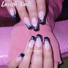 For a bold and edgy look, these long, square-tipped nails feature hand-painted black and white flames over a neutral base. The design includes a touch of glitter within the flame outline, adding depth and a subtle sparkle to this statement manicure.