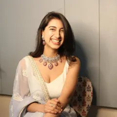 A happy client glowing in her custom-made pink stone and Polki jewellery set. Her smile says it all.