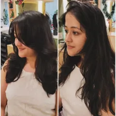 A classic before-and-after of a haircut. The new layered style adds volume and shape, completely transforming her look from simple to sophisticated.