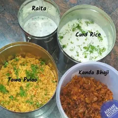 Here is a look at a typical daily meal delivery. This set includes flavorful tawa pulao, cooling raita, comforting curd rice, and crispy kanda bhaji, all prepared fresh in my kitchen.