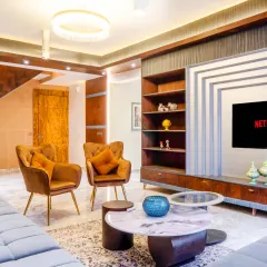 A full view of the living area, showing how the different elements come together. From the modern chandelier to the custom coffee table and plush seating, every piece is chosen to create a cohesive and luxurious feel.