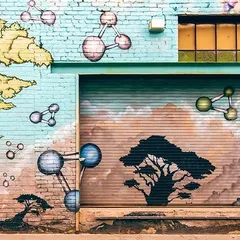 This large-scale exterior mural combines scientific and natural elements, painted across a brick wall and metal shutter. We are equipped to handle complex surfaces and large projects.