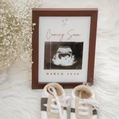 A beautiful flat-lay announcement. We framed the sonogram with the due date and placed it next to a tiny pair of baby shoes. It's a simple, stylish, and heartwarming way to share the big news.